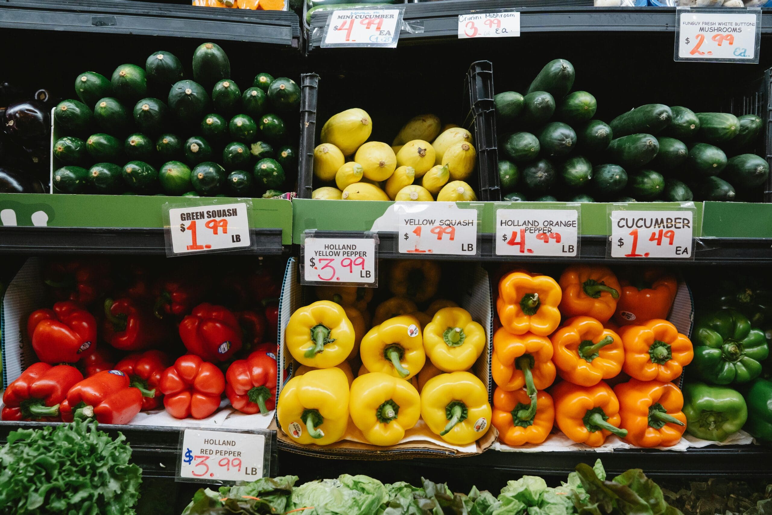 Colorful display of fresh vegetables and fruits at grocery store representing whole food plant-based wellness retreat nutrition