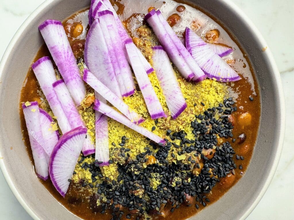 Bowl of chili topped with black sesame seeds demonstrating easy meal integration