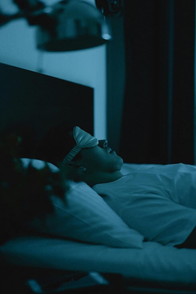 Person sleeping in dark bedroom representing quality sleep for brain health